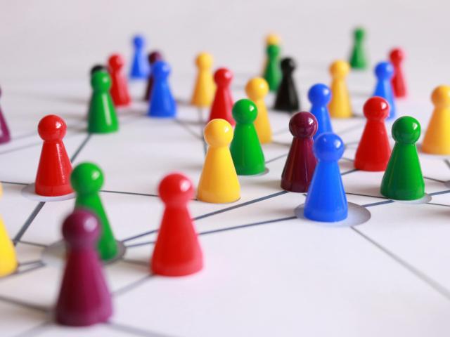 Colorful plastic game pieces on a white board with connected lines