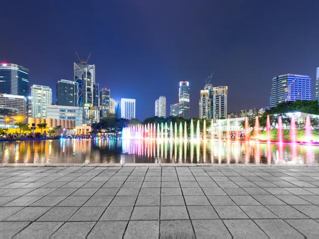 Office buildings with colorful lights along a gray path