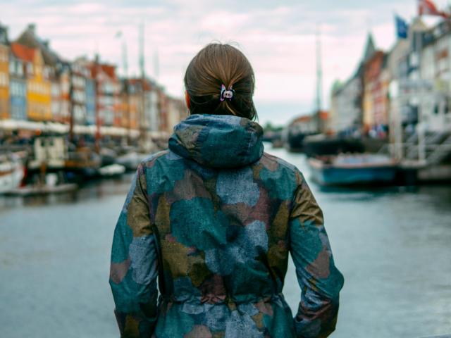 A woman with her back to the camera looks out at a dock in Denmark