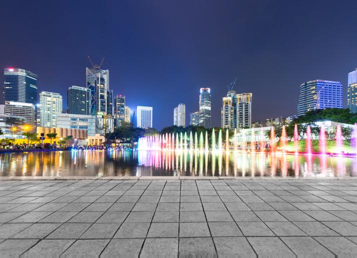 Office buildings with colorful lights along a gray path