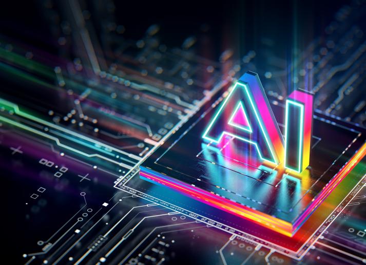 A computer chip lit with neon colors with "AI" in 3D letter on top of it