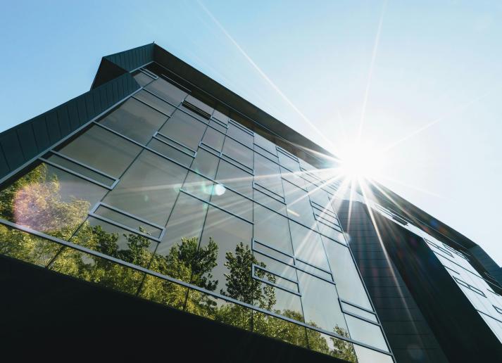 a building with the reflection of trees in the windows