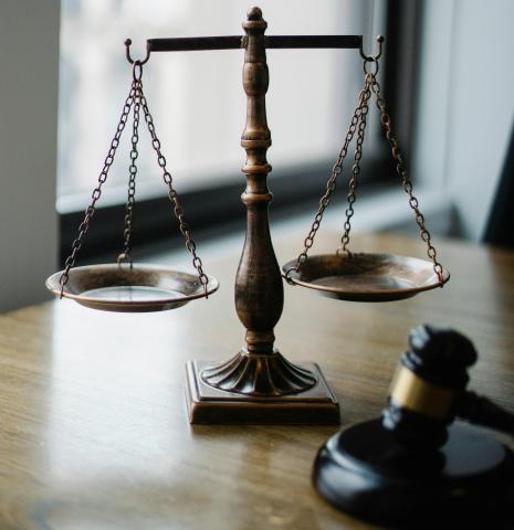 Scales and a gavel on a desk by a window