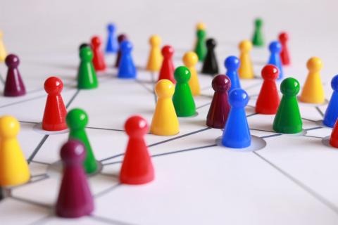 Colorful plastic game pieces on a white board with connected lines