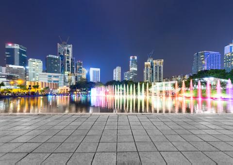 Office buildings with colorful lights along a gray path