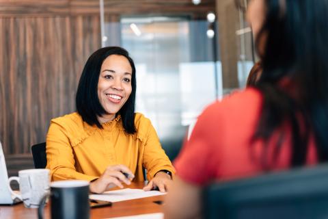 Woman speaking to client at office over the table