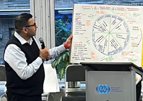 A man standing in front of a whiteboard and giving a lecture